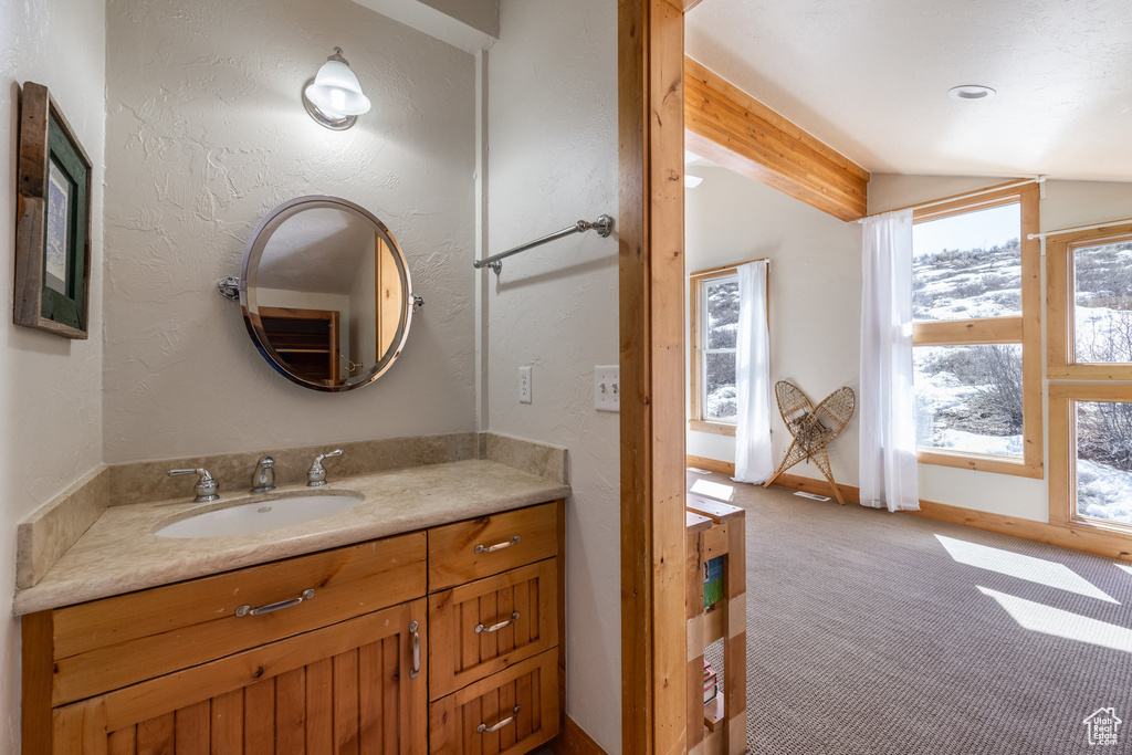 Bathroom featuring lofted ceiling with beams and vanity