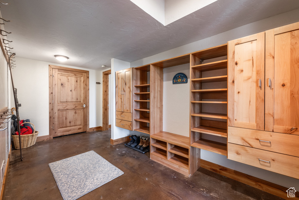 Mudroom featuring baseboards and concrete floors