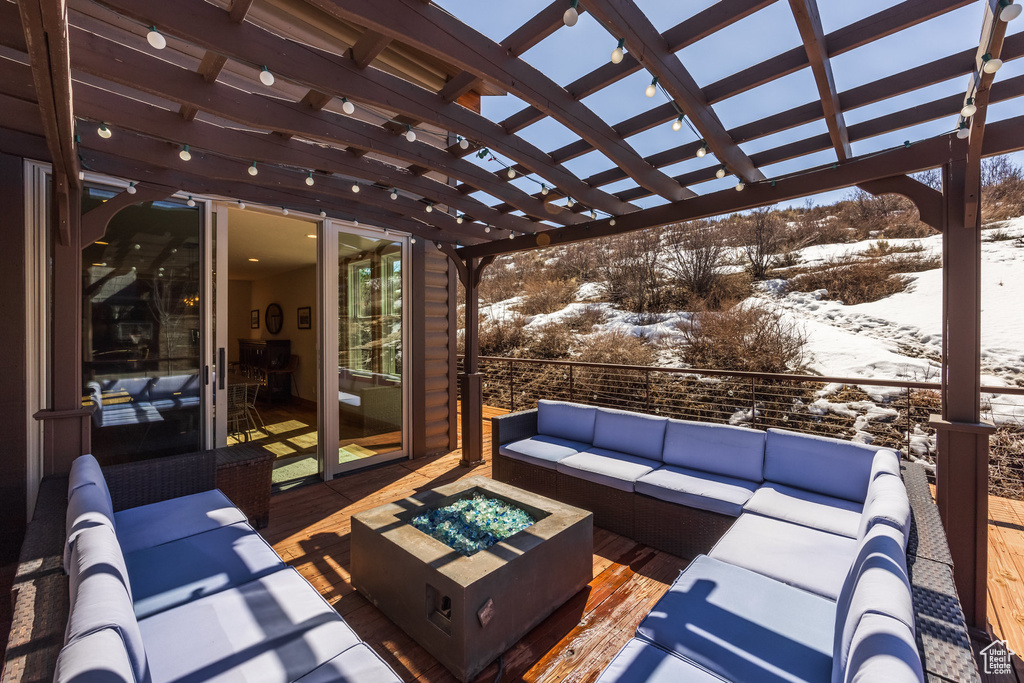 Snow covered patio with an outdoor living space with a fire pit and a pergola
