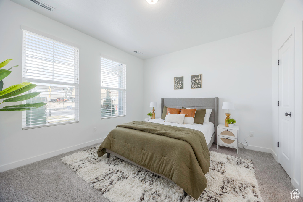 Bedroom with baseboards, visible vents, and carpet