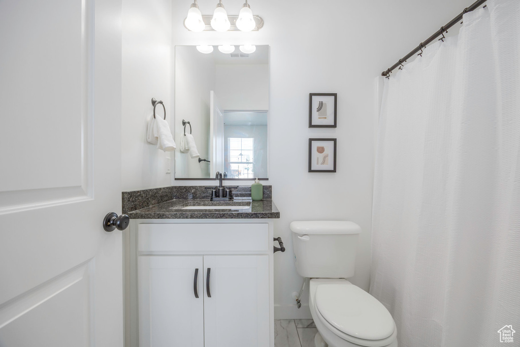 Full bath featuring marble finish floor, toilet, and vanity