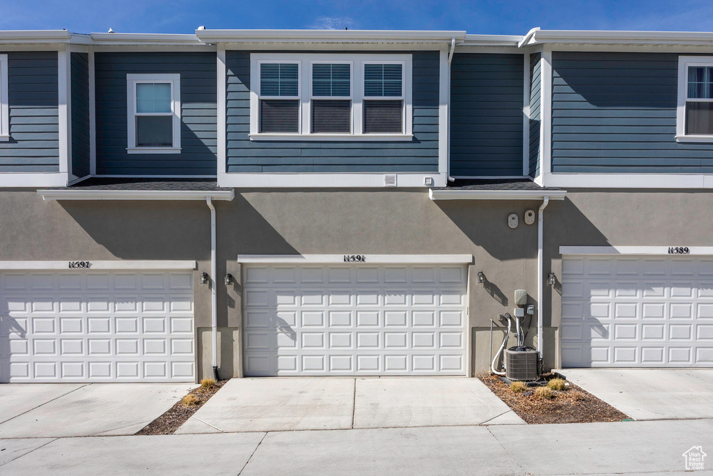 View of front of house with stucco siding, a garage, and concrete driveway