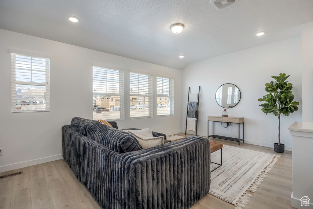 Living room featuring recessed lighting, baseboards, light wood-style floors, and visible vents