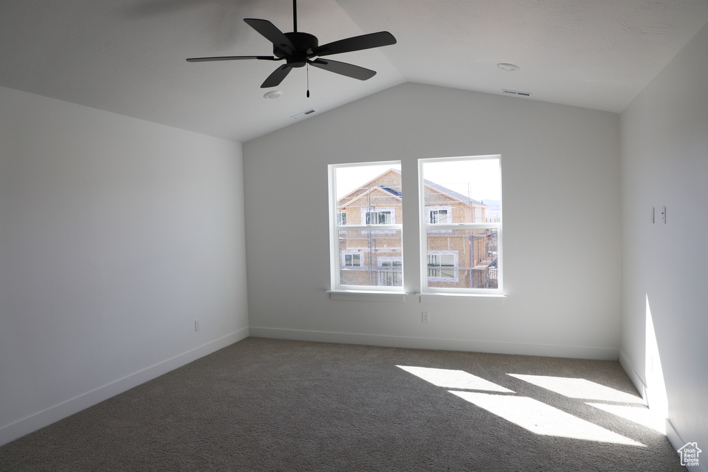 Unfurnished room with carpet flooring, baseboards, vaulted ceiling, and visible vents