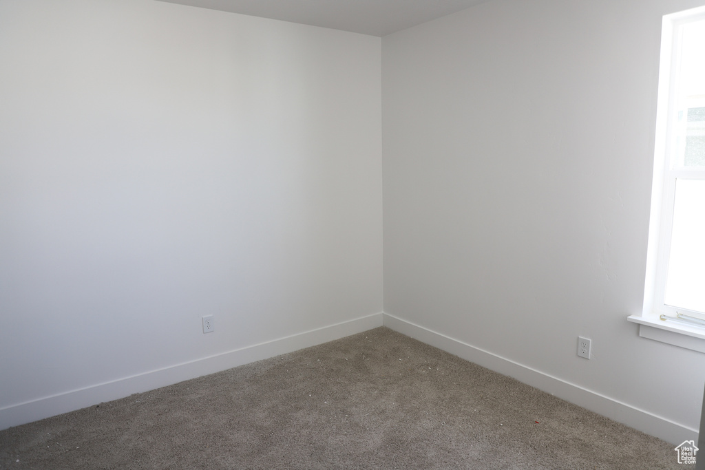 Empty room with baseboards and carpet