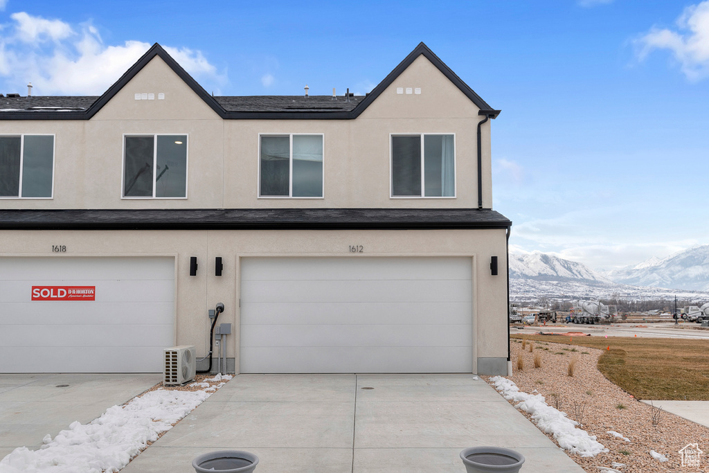 View of front of house featuring driveway, a garage, and stucco siding