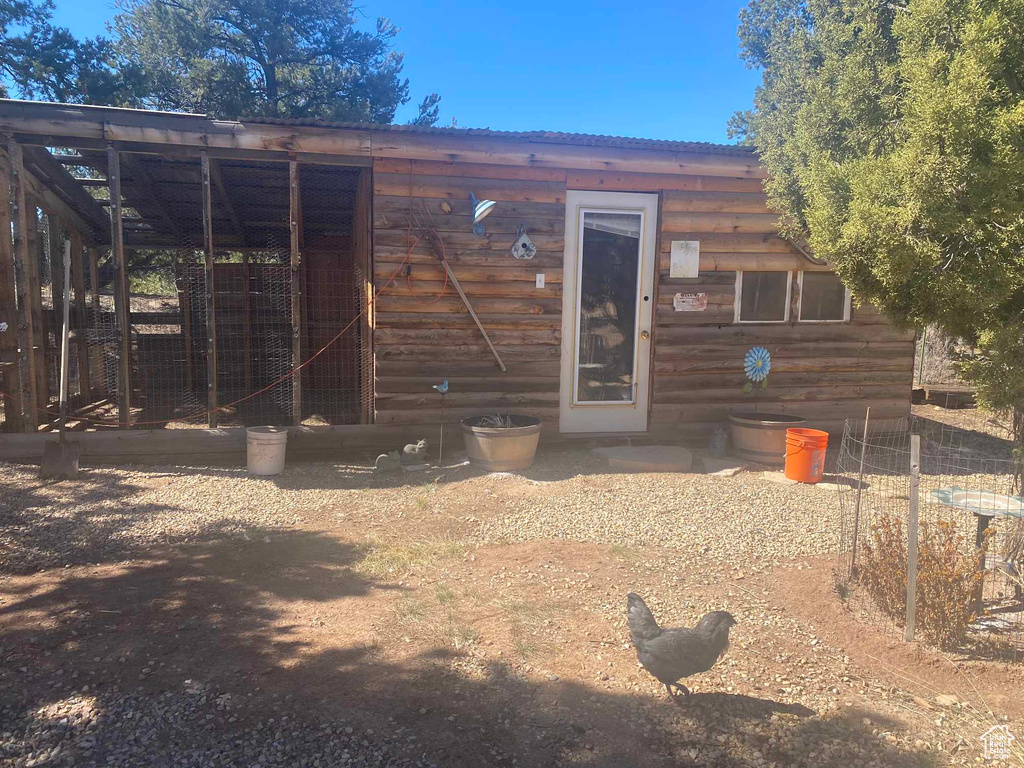 Rear view of property featuring exterior structure and an outbuilding