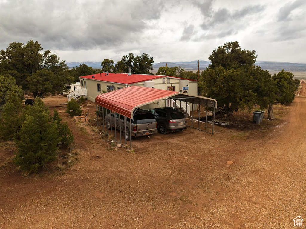 Exterior space with driveway, metal roof, and a carport