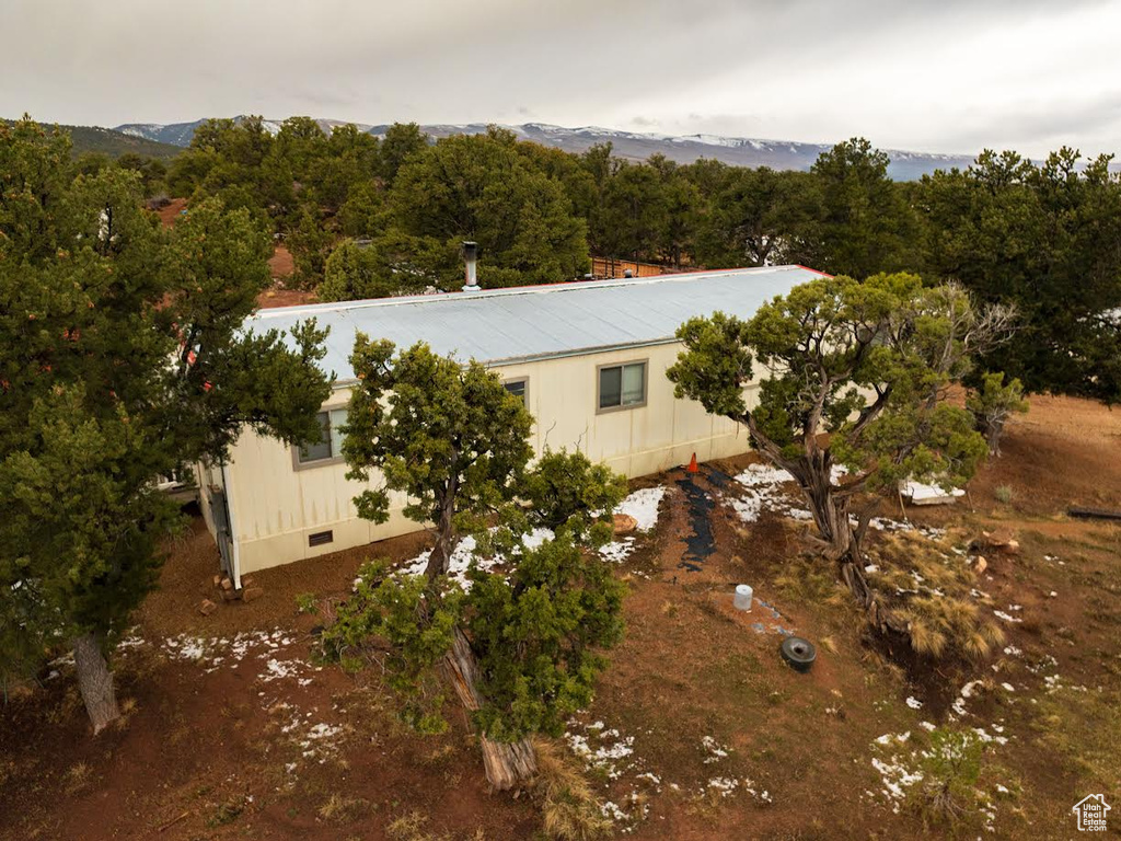 View of property exterior with crawl space and a view of trees