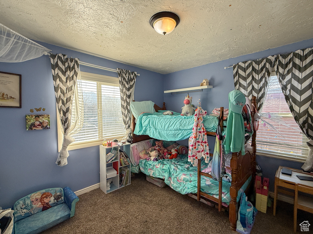 Bedroom featuring baseboards, carpet floors, and a textured ceiling