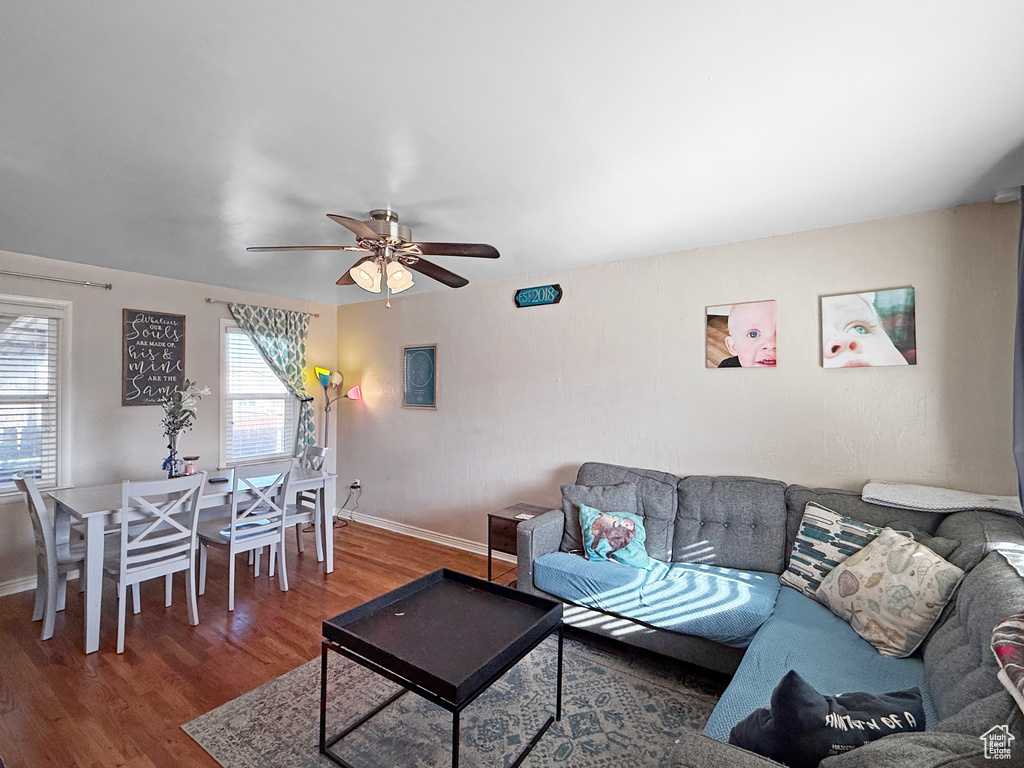 Living room with baseboards, wood finished floors, and a ceiling fan