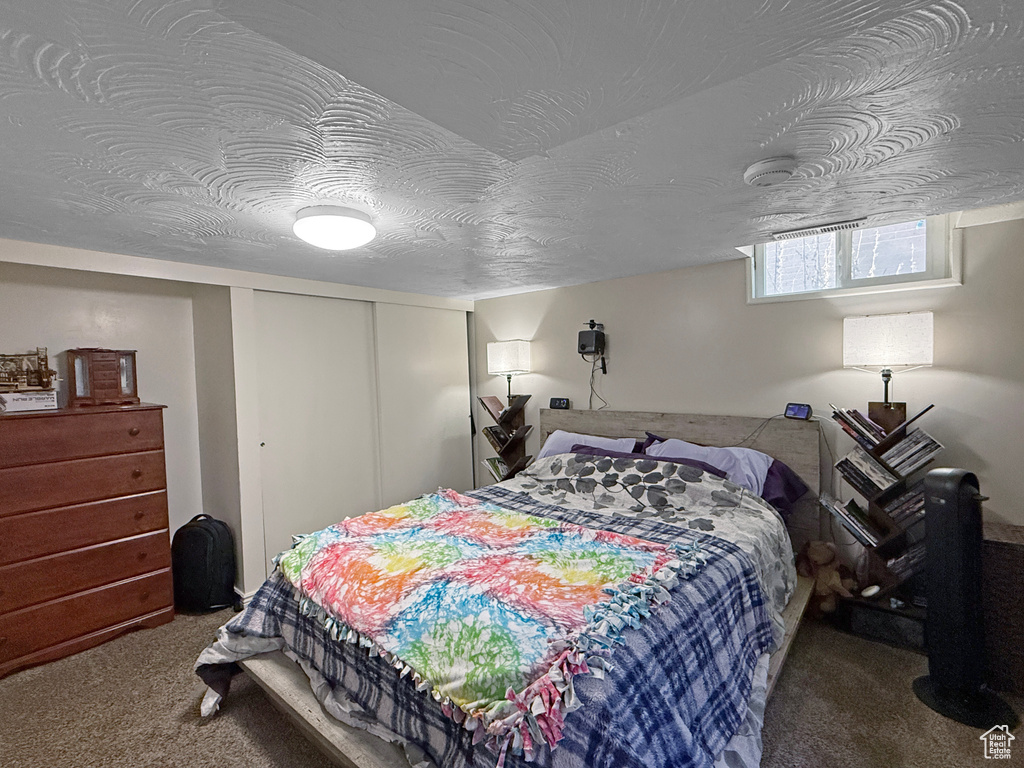 Bedroom featuring a closet, a textured ceiling, and carpet