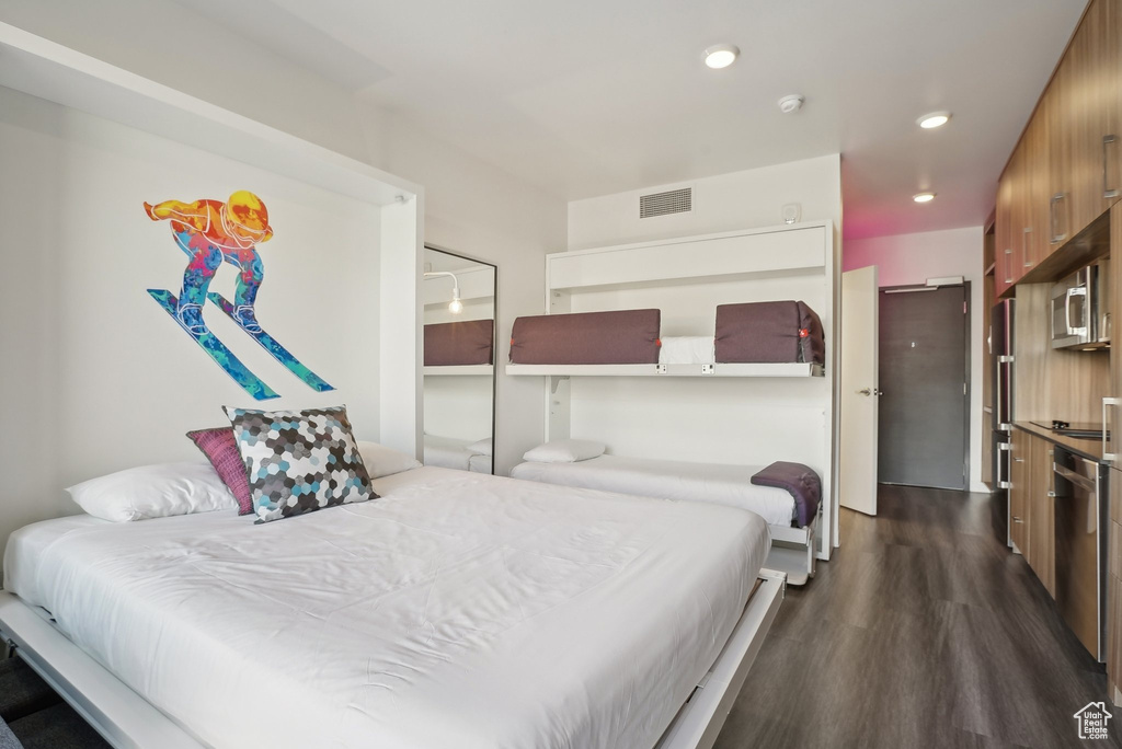 Bedroom with dark wood-style floors, visible vents, and recessed lighting