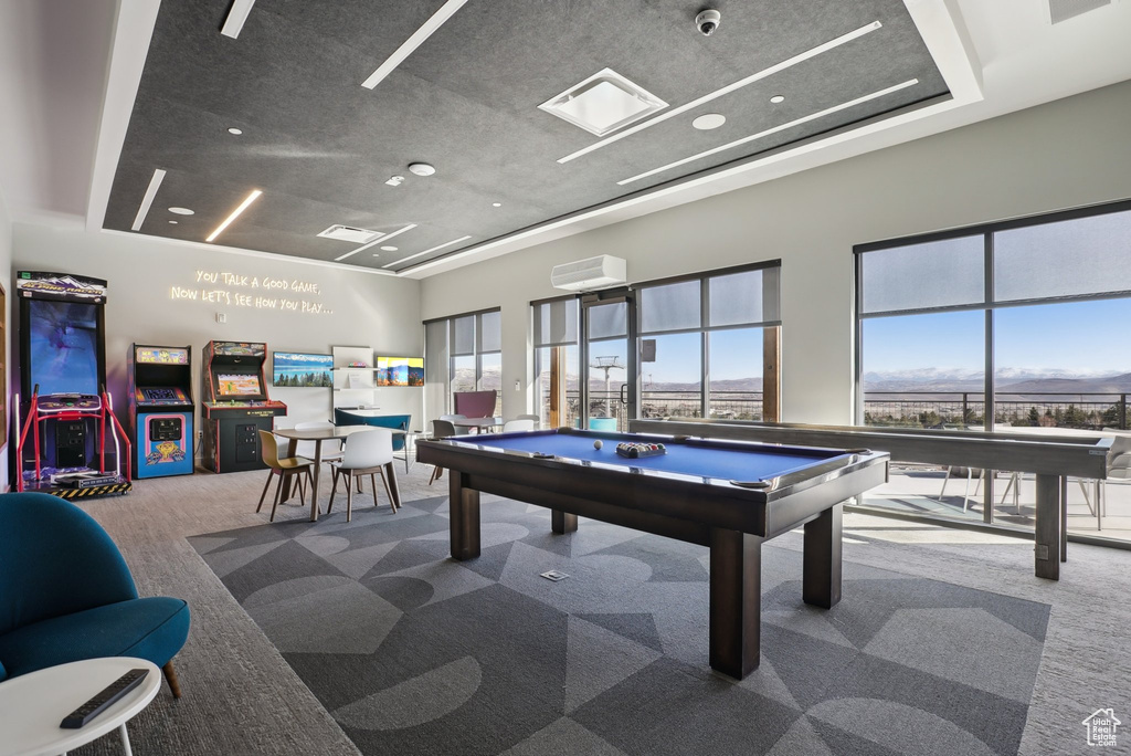 Rec room featuring carpet floors, a wall unit AC, billiards, visible vents, and a towering ceiling