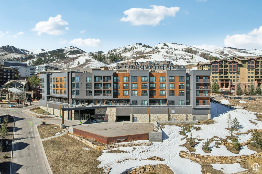 Snow covered rear of property featuring a mountain view