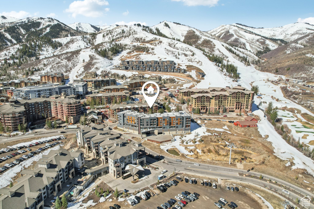 Snowy aerial view with a mountain view and a view of city