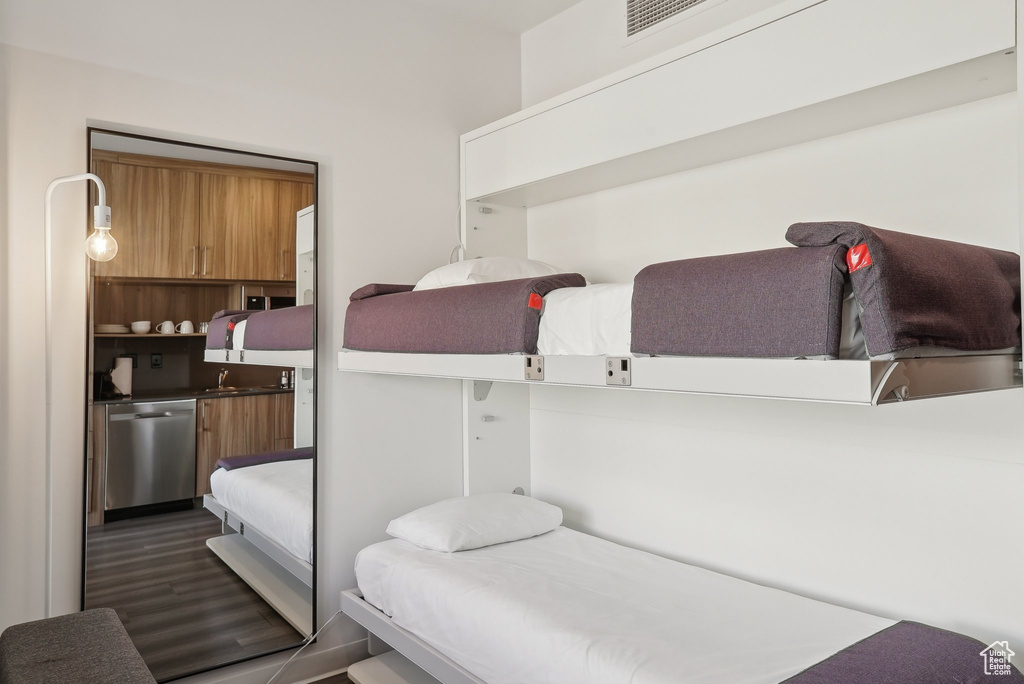 Bedroom with dark wood-type flooring and visible vents