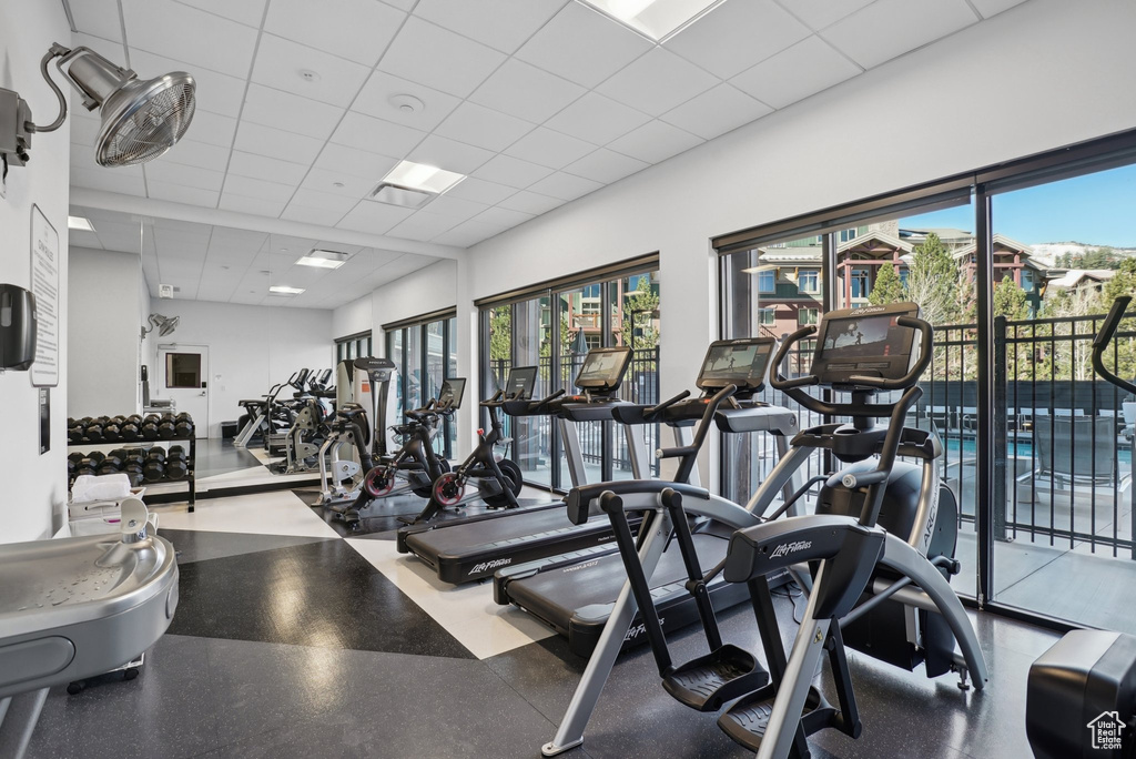 Exercise room featuring a drop ceiling and plenty of natural light