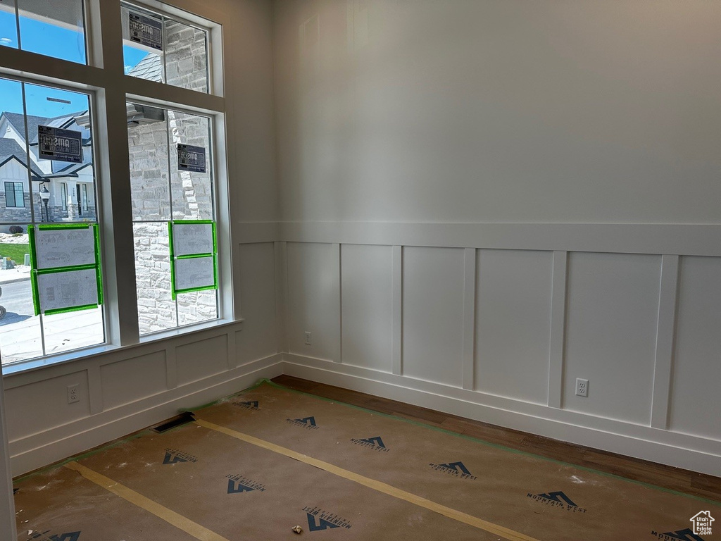 Spare room with a decorative wall and a wainscoted wall