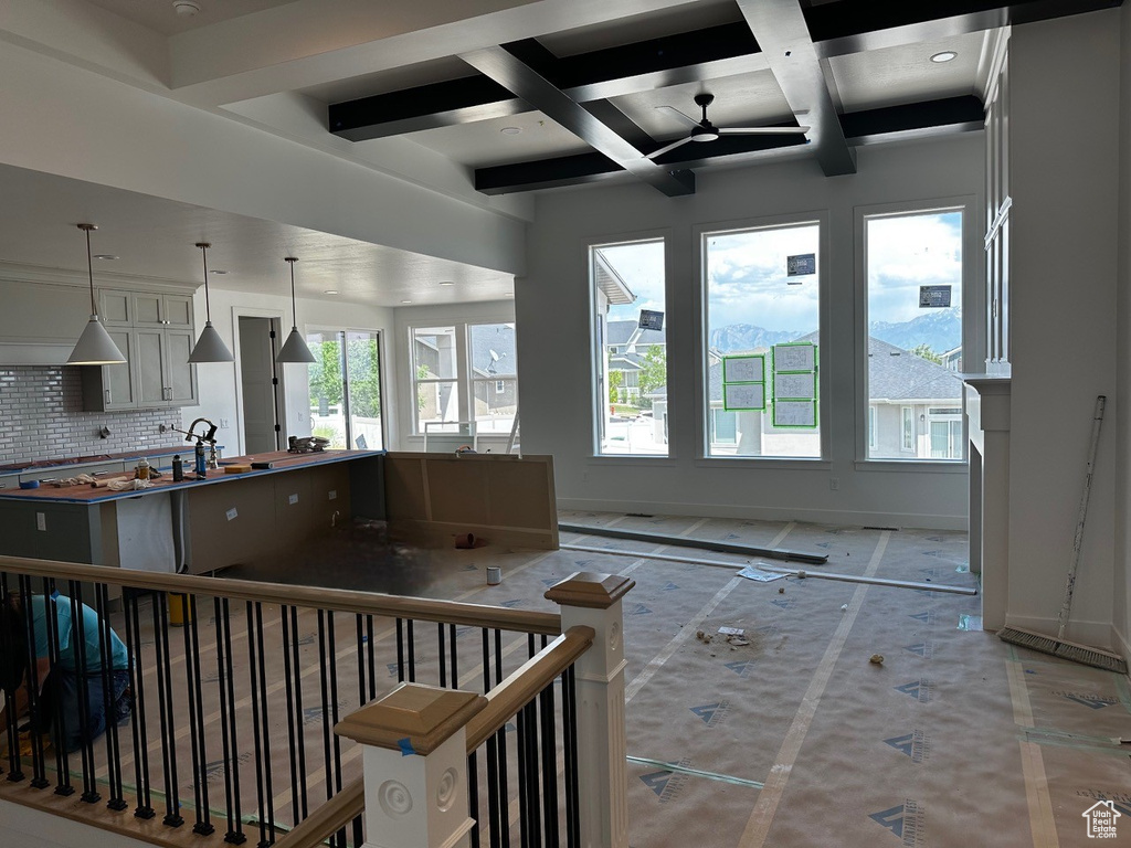 Kitchen featuring backsplash, baseboards, coffered ceiling, beam ceiling, and decorative light fixtures