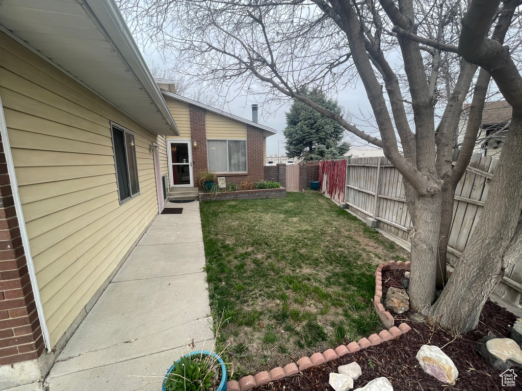View of yard with fence and entry steps
