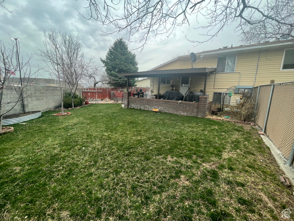 View of yard featuring a fenced backyard and a patio area