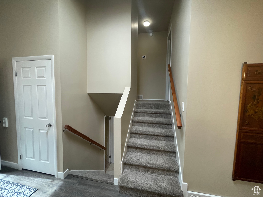 Stairs featuring baseboards, visible vents, and wood finished floors