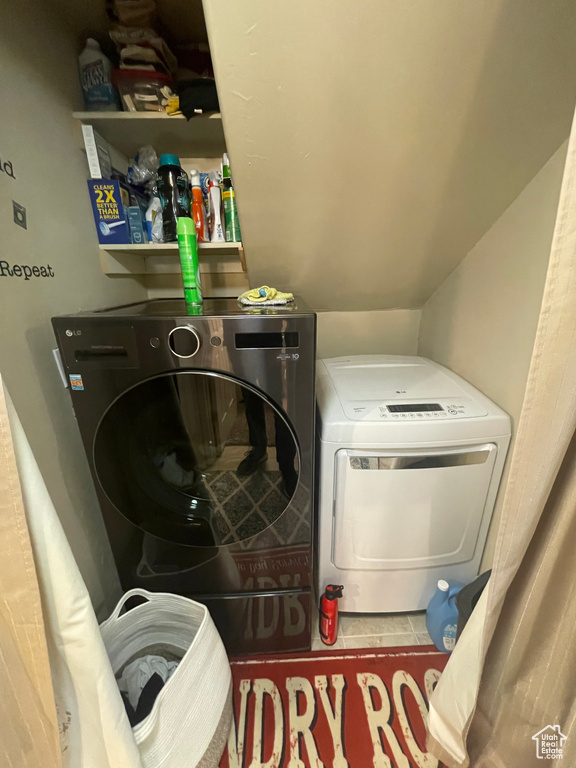 Washroom featuring laundry area, tile patterned flooring, and washer and dryer