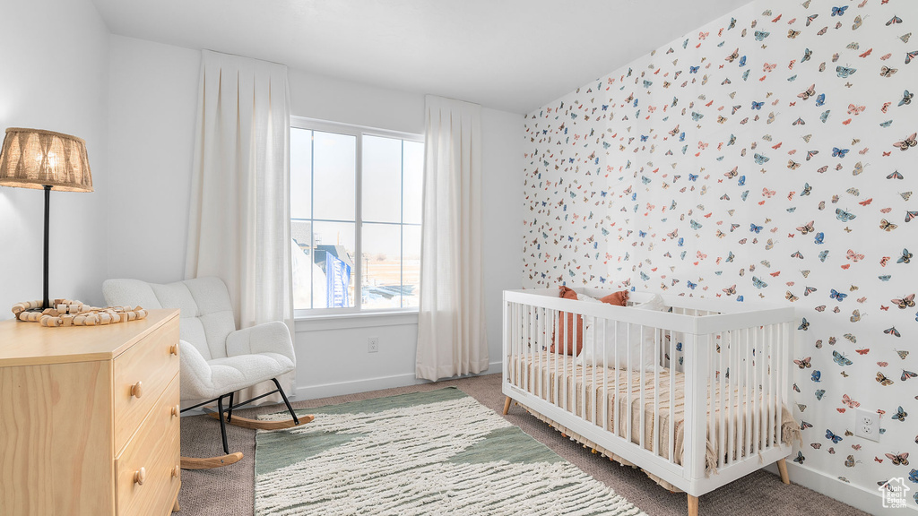 Bedroom featuring carpet flooring, a nursery area, and baseboards