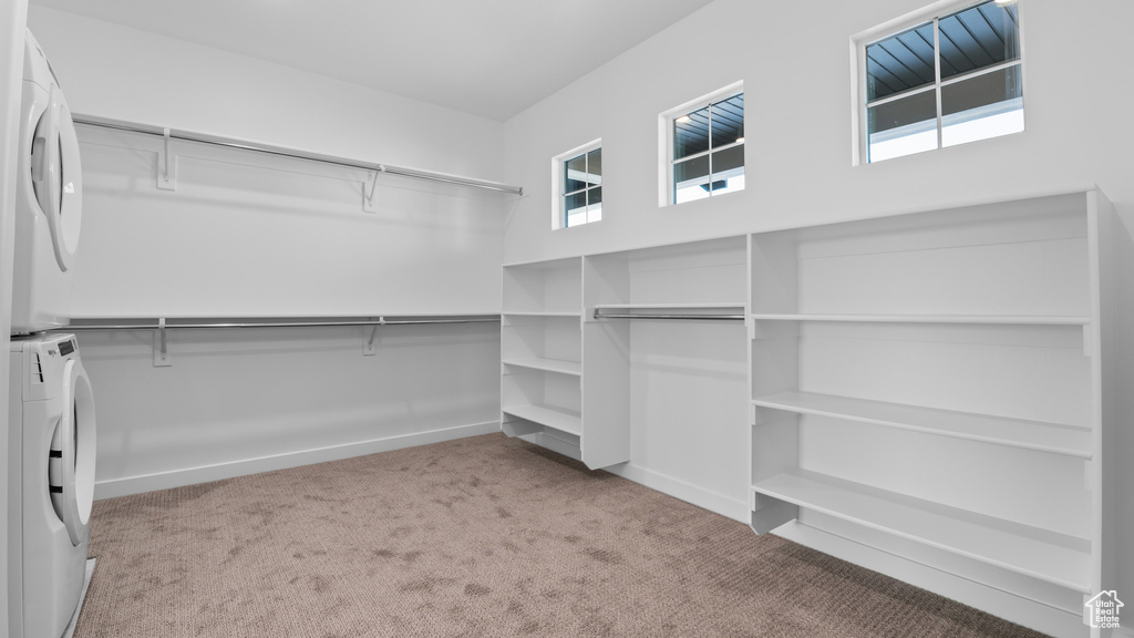 Spacious closet with carpet floors and stacked washer and dryer