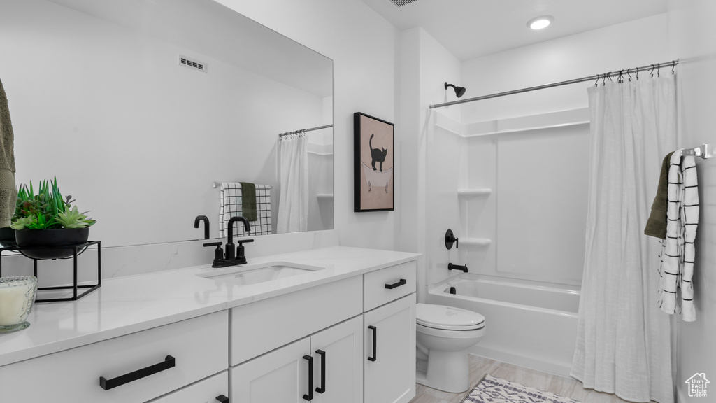 Bathroom featuring vanity, shower / bath combo with shower curtain, toilet, wood finished floors, and visible vents