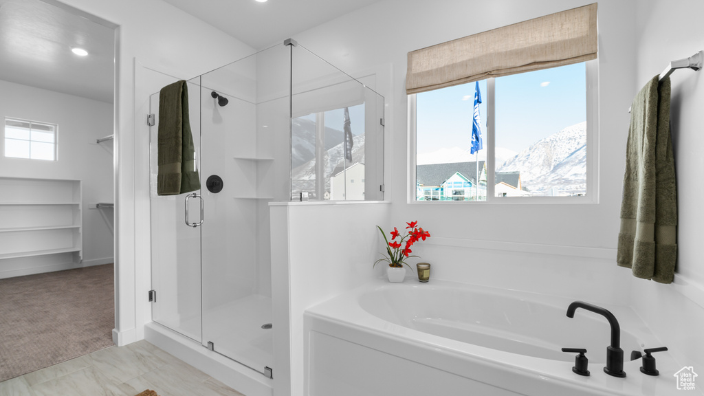 Bathroom with recessed lighting, a garden tub, and a stall shower