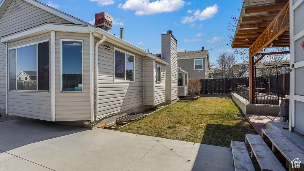 View of yard with fence and a patio
