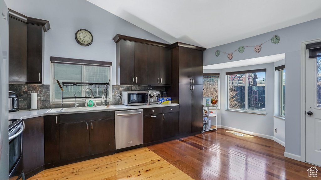 Kitchen featuring light countertops, vaulted ceiling, light wood finished floors, and appliances with stainless steel finishes