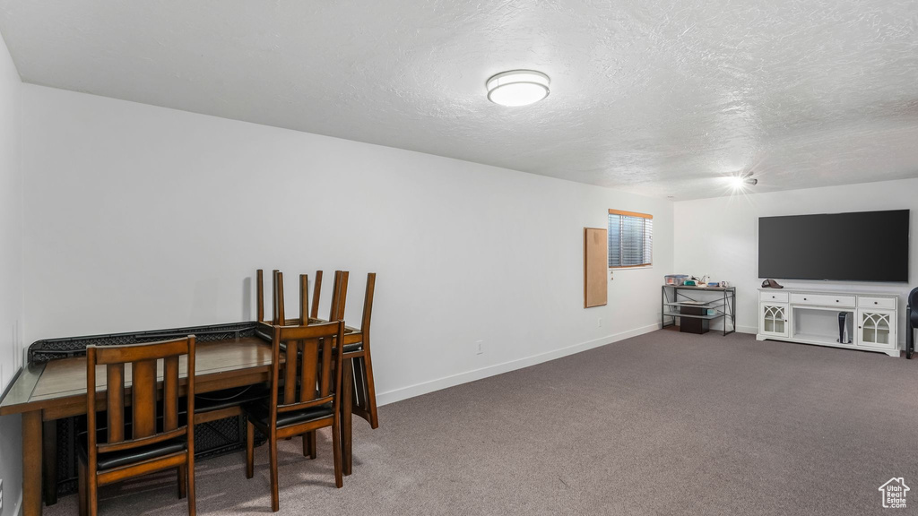 Office area with carpet flooring, baseboards, and a textured ceiling