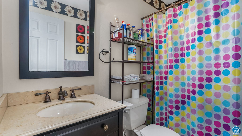 Full bath featuring a shower with curtain, toilet, and vanity
