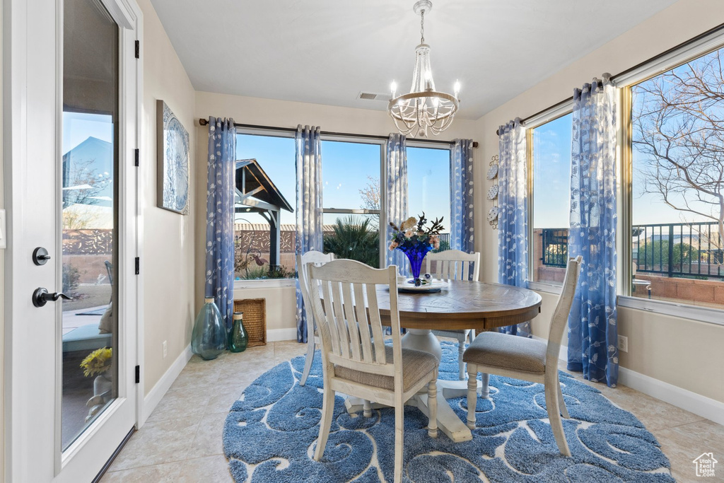Dining room with a chandelier, visible vents, a healthy amount of sunlight, and baseboards