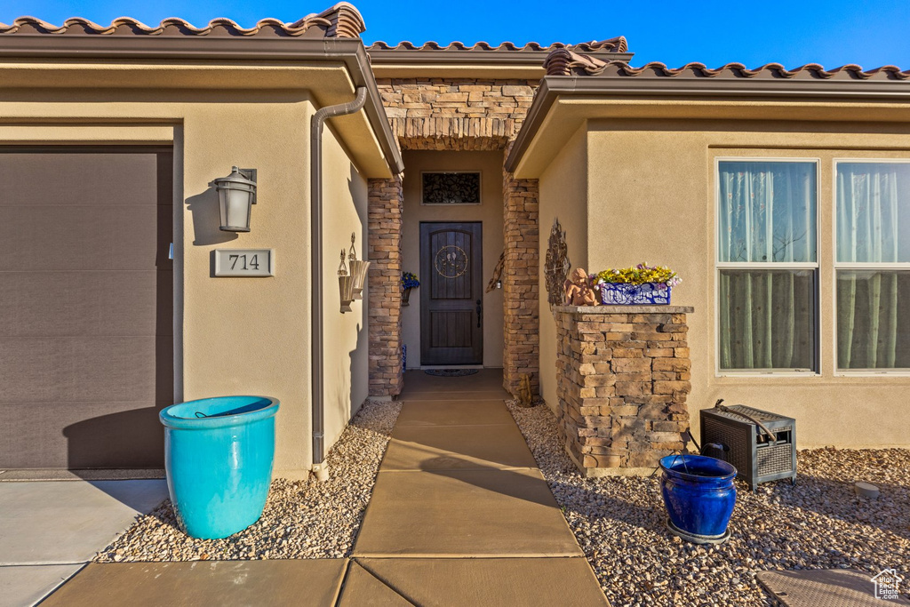 View of exterior entry with stucco siding and stone siding