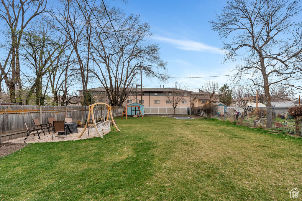 View of yard with a fenced backyard, a patio area, and a playground