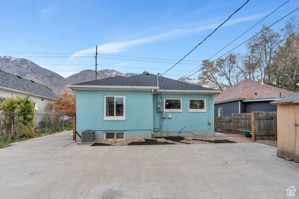 Rear view of property featuring a fenced backyard, central AC, a mountain view, and a patio