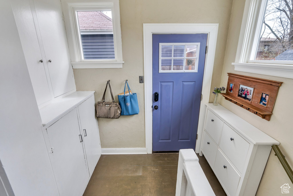 Interior space with baseboards and dark wood-type flooring