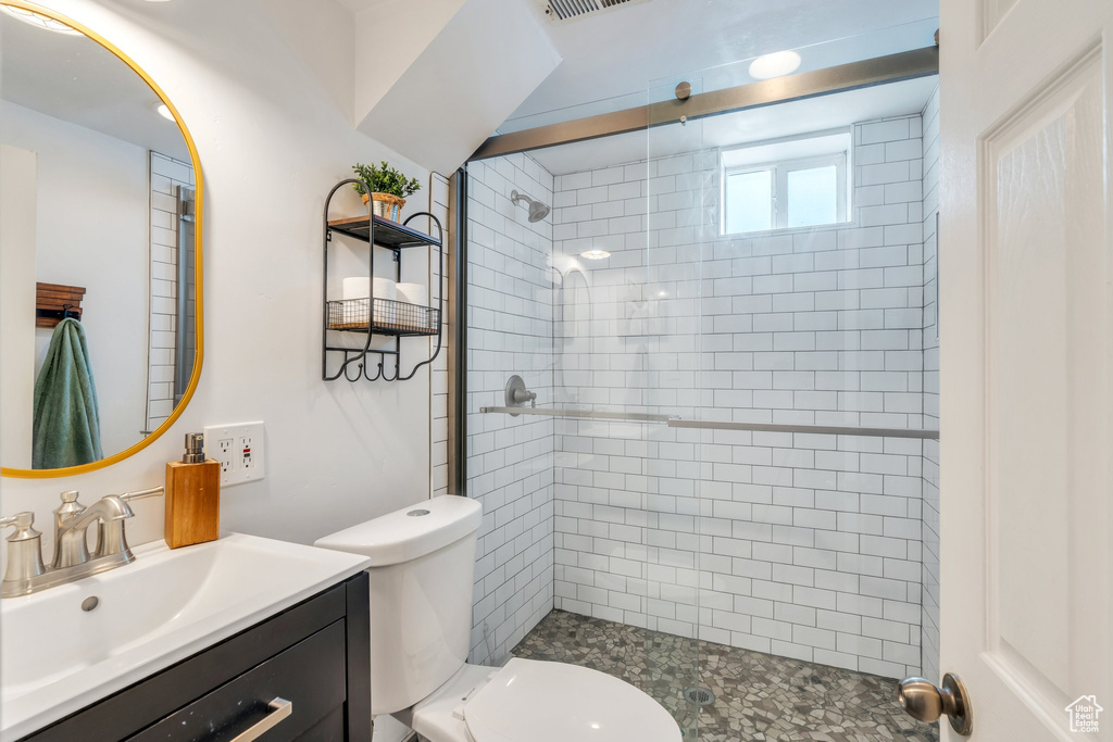 Full bath featuring vanity, visible vents, toilet, and a shower stall