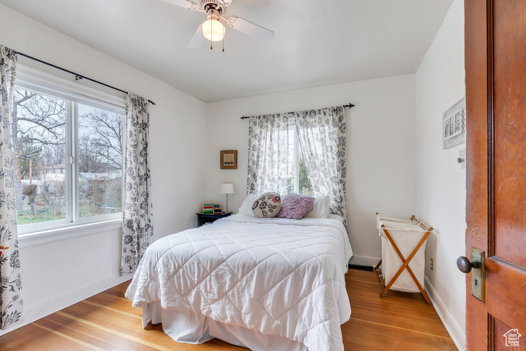 Bedroom with baseboards, light wood-style flooring, and a ceiling fan