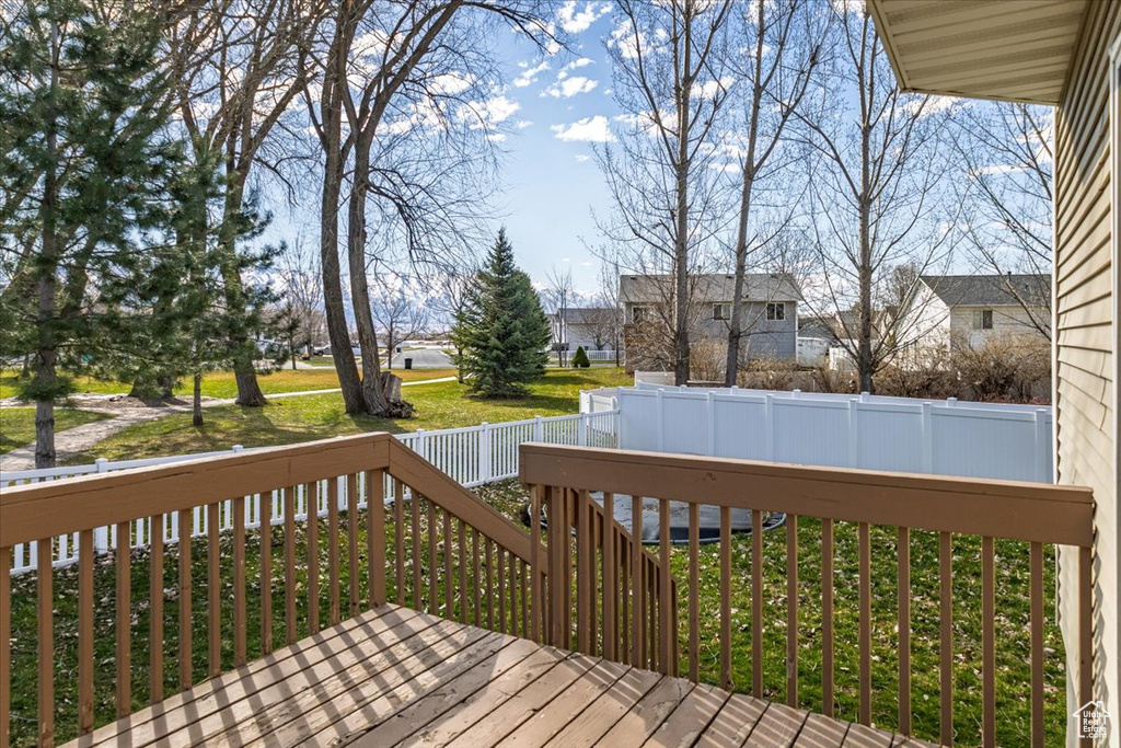 Deck featuring a yard, fence, and a residential view
