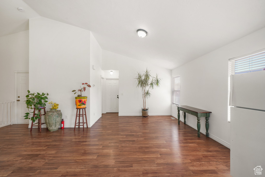Entryway featuring high vaulted ceiling, wood finished floors, and baseboards