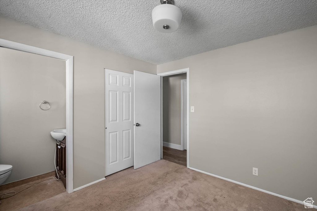Unfurnished bedroom featuring carpet flooring, baseboards, and a textured ceiling