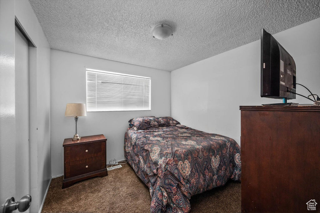 Bedroom with carpet flooring and a textured ceiling