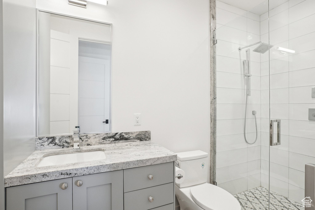 Full bathroom with toilet, a shower stall, and vanity
