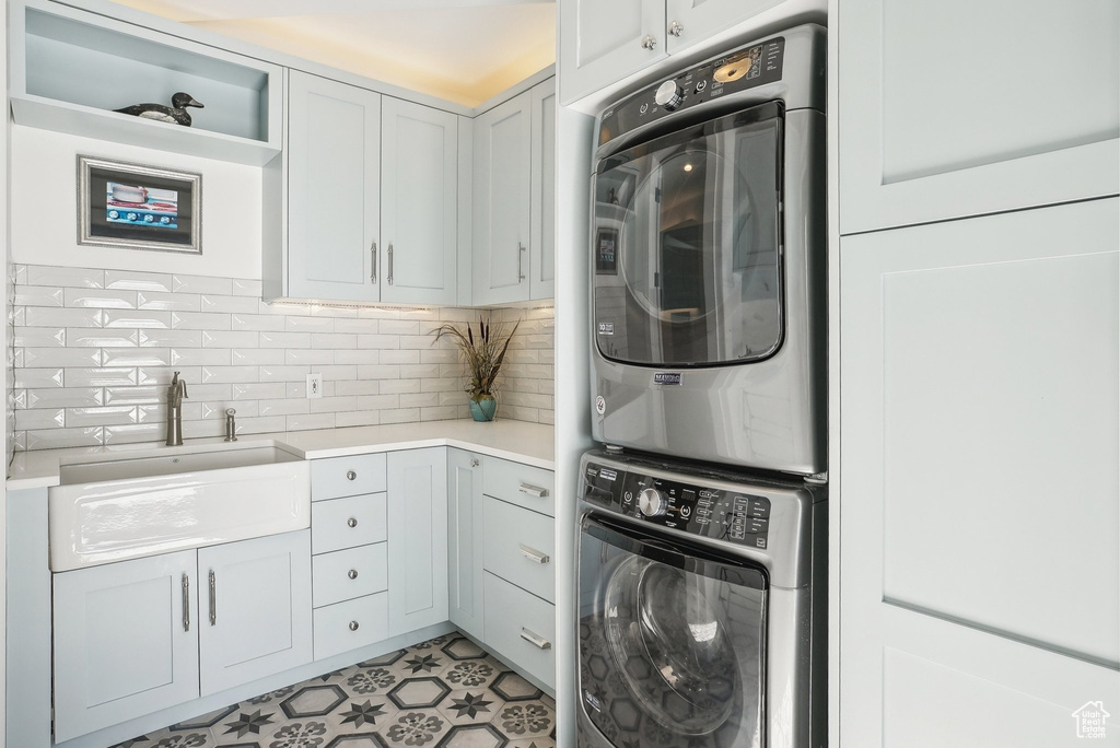 Laundry room with cabinet space and stacked washer and clothes dryer