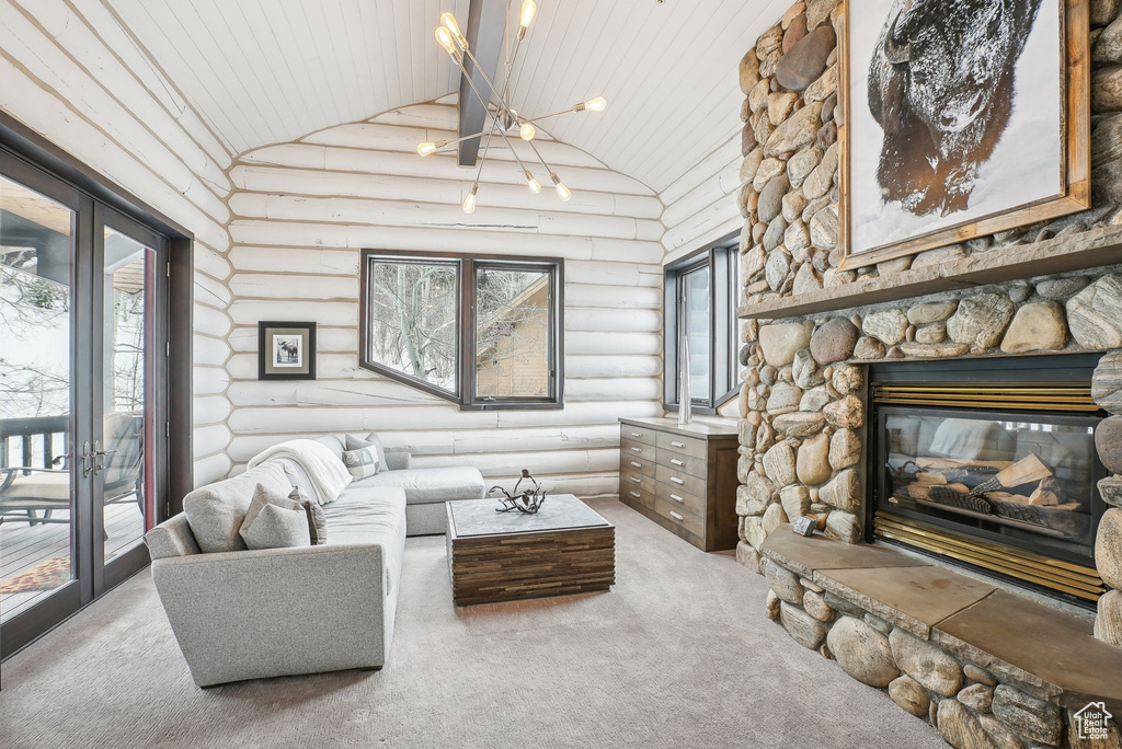 Carpeted living room with rustic walls, high vaulted ceiling, wood ceiling, plenty of natural light, and a stone fireplace